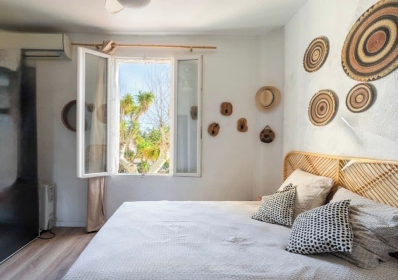 Une chambre à coucher avec un lit, une fenêtre et des éléments décoratifs sur les murs.