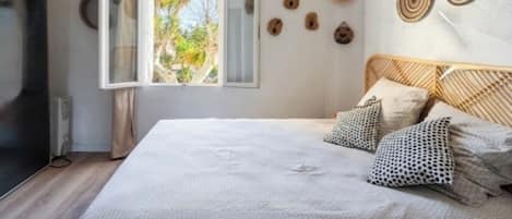 A bedroom with a bed, a window, and wall decorations.