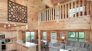 Una cabaña con cocina, comedor y sala de estar con sofá y mesa de centro.