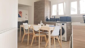A modern kitchen with a dining area, built-in appliances, and a view of the outside.