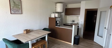 Un espacio habitable compacto con comedor, kitchenette y sofá.