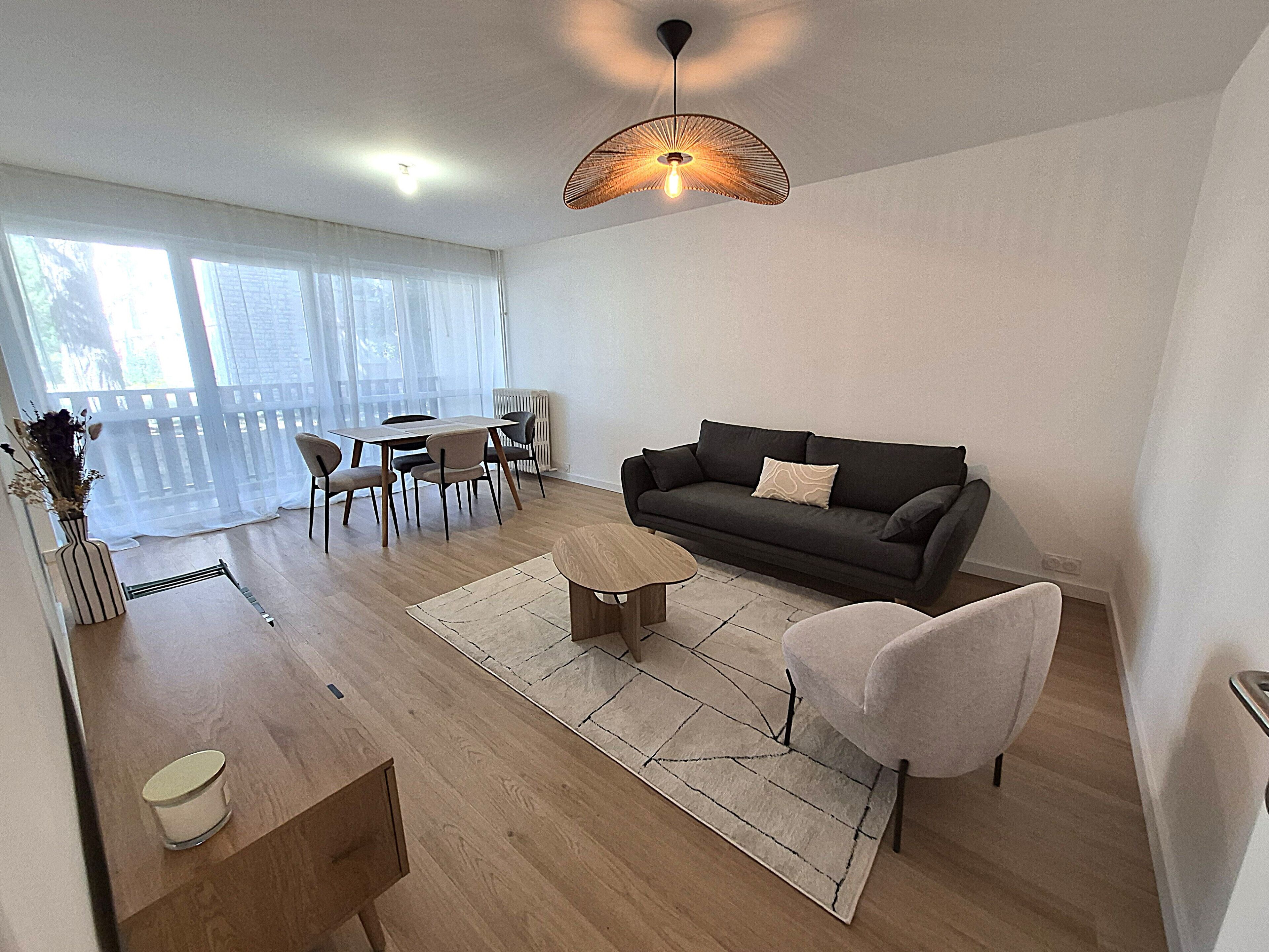 Ein stilvolles Wohnzimmer mit Sofa, Couchtisch und Essbereich.