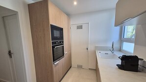A compact kitchen with a built-in microwave, oven, and a small sink. - 2-bedroom apartment with balcony in Annecy (Annecy)