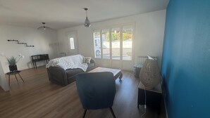 Un soggiorno con un divano, una poltrona, un tavolo e una lampada decorativa.
