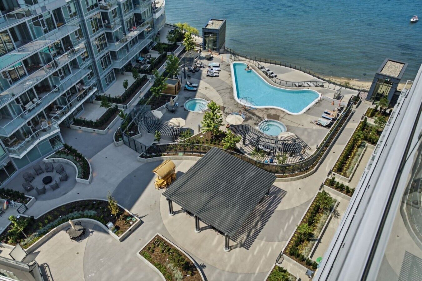 Un edificio de gran altura con piscina en la azotea, zonas de descanso y vistas al mar.