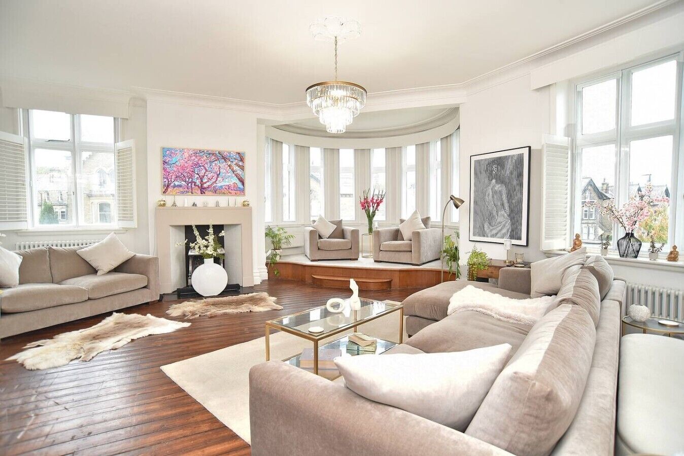 A spacious living room with a fireplace, comfortable seating, and large windows.