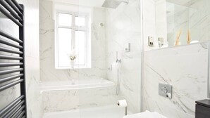 Ein modernes Badezimmer mit Badewanne, Dusche und Toilette.