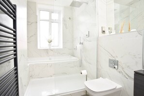 A modern bathroom with a bathtub, shower, and toilet. - Beautiful & Luxury Apartment Overlooking The Stray (North Yorkshire)