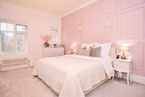 A bedroom with a large bed, bedside tables, a radiator, and a window with blinds. - Beautiful & Luxury Apartment Overlooking The Stray (North Yorkshire)