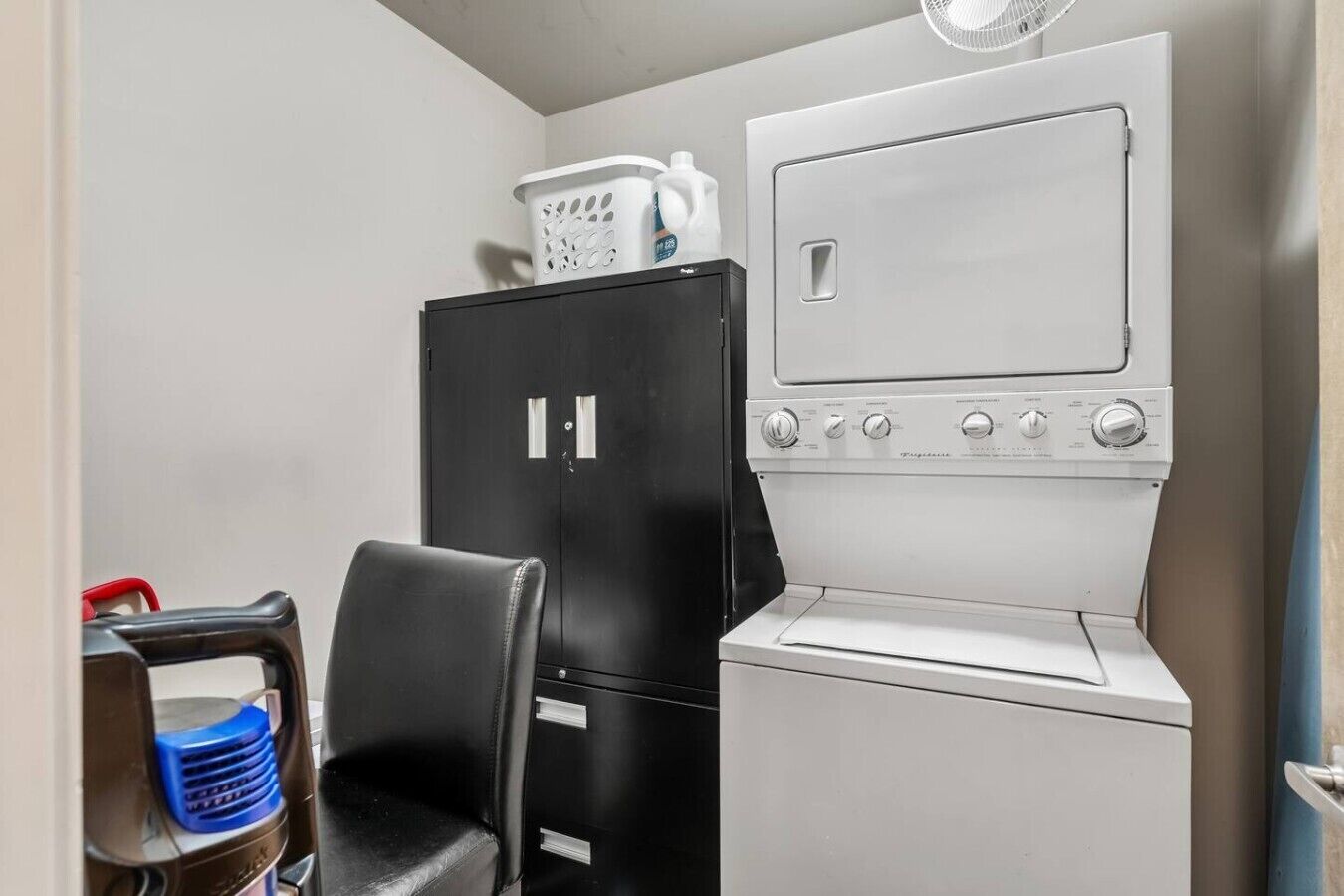Una kitchenette compacta con refrigerador, microondas y lavamanos.