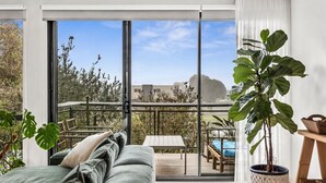 Ein Balkon mit Blick auf eine Stadtlandschaft, ein Holzdeck und ein Bett mit Aussicht.