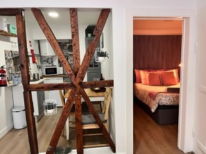 A modern kitchen with white appliances and a wooden beam structure. - Central Apartment "Casa Dos Lagares" (Lisbon)