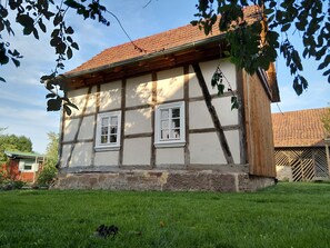 A traditional half-timbered house with a tiled roof and two windows. - LANDHAUS ELLENBACH - Romantic Half-Timbered Charm on the Fulda River, Cozy Vacation Rental in a Historic Building (Alheim)
