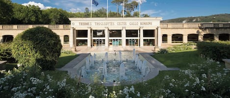 Un bâtiment de style classique doté d’une cour intérieure, de colonnes et d’une fontaine.