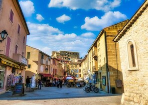 A cobblestone street with buildings, a café, and a bicycle. - A one-bedroom apartment ideally located for wellness treatments, relaxation, and exploring the Verdon (Gréoux-les-Bains)
