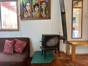 Una sala de estar con un sofá marrón, un tapete verde, un mueble de madera y un cuadro en la pared.