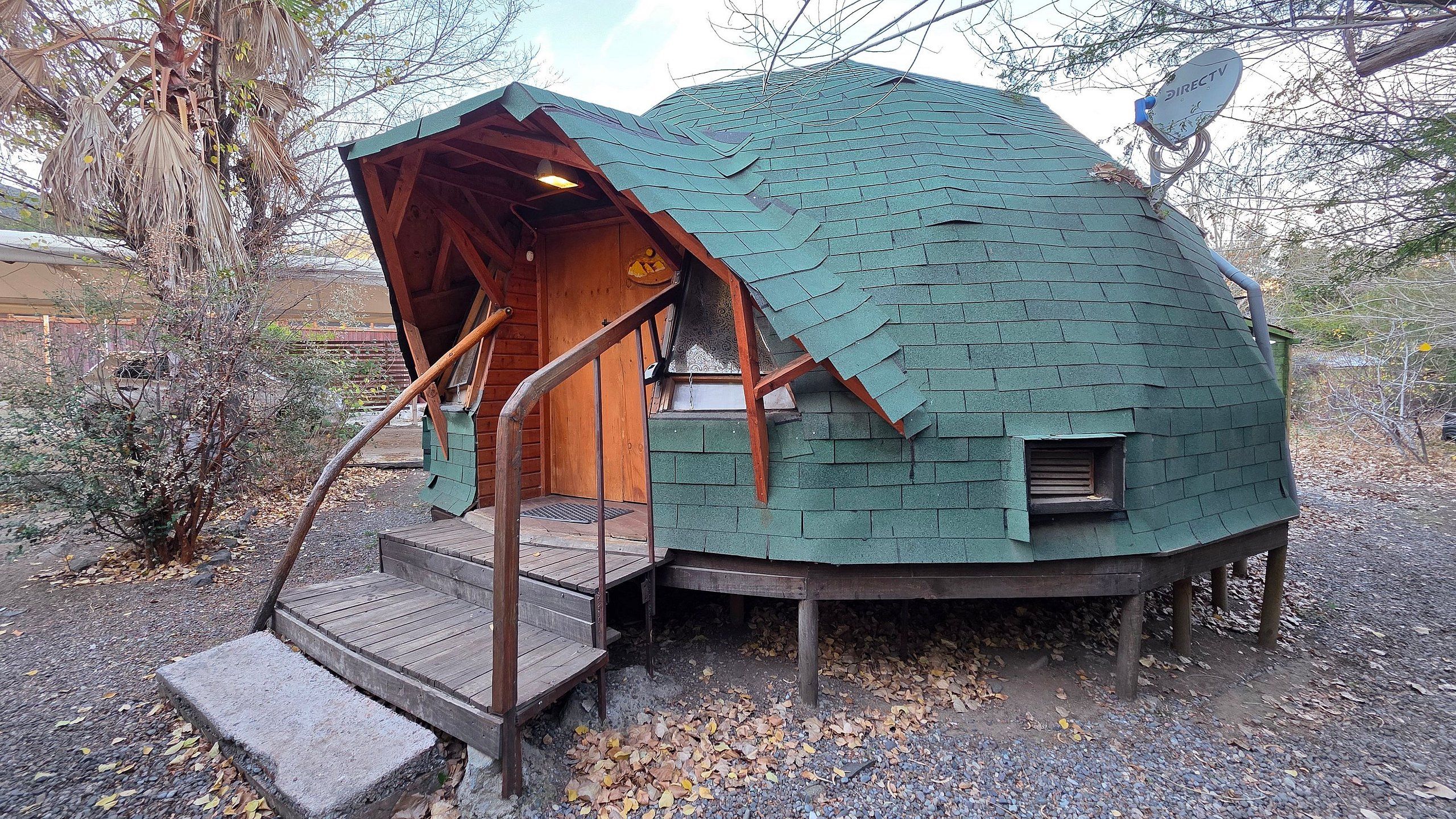 A dome-shaped building with a wooden staircase leading to a door.
