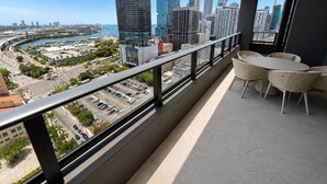 A balcony with a view of a cityscape, including high-rise buildings and a body of water. - 2 Bedrooms Condo with Balcony & Amazing Views in Downtown (Miami)