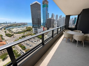 A balcony with a view of a cityscape, including high-rise buildings and a body of water. - 2 Bedrooms Condo with Balcony & Amazing Views in Downtown (Miami)