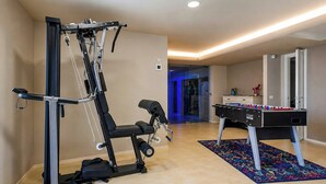 Ein Heimfitnessraum mit einer Gewichtshalterung, einer Klimmzugstange und einem Kicker.