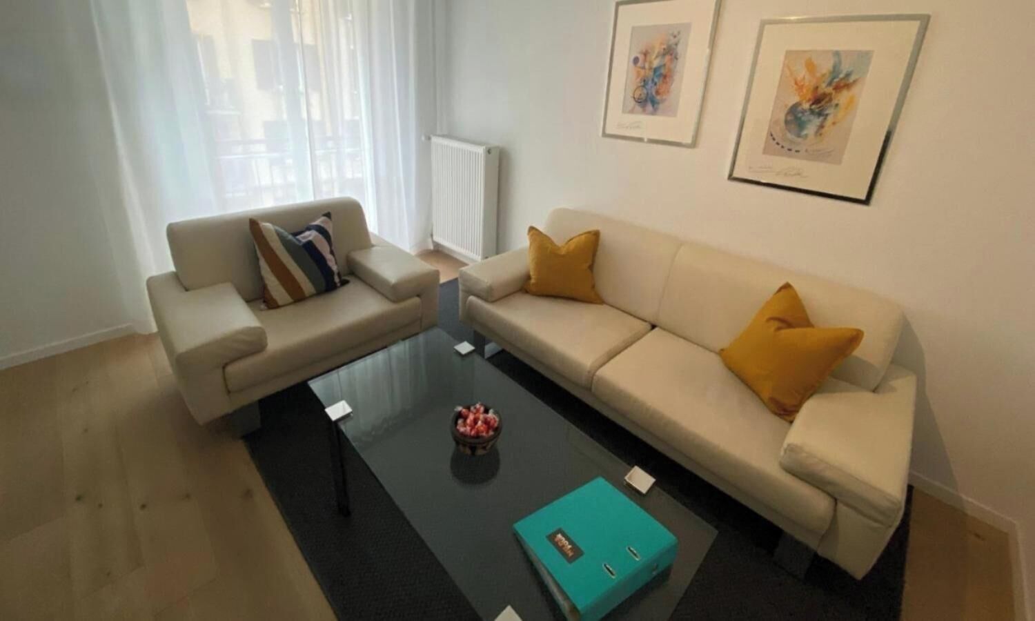 A modern living room with two sofas, a coffee table, and artwork on the wall.