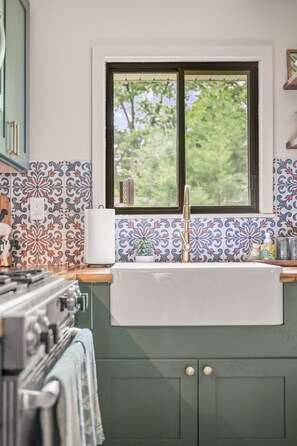 A kitchen with a window, a sink, and a stove. - Flossie's and Maudie's Lake Retreat (Lyon Township)