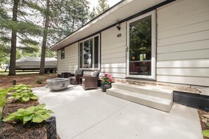 A residential house with a covered porch, outdoor seating, and a fire pit. - Flossie's and Maudie's Lake Retreat (Lyon Township)