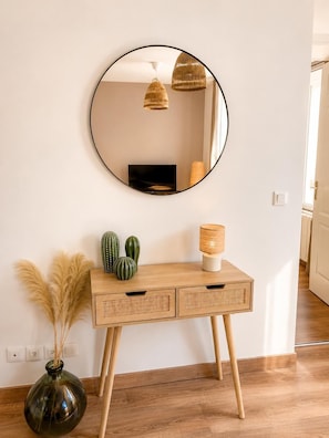 A wooden console table with a round mirror above it, a vase with pampas grass, and two cacti. - In the Heart of Vernon • Serves 4 • 10 minutes from Giverny (Vernon)