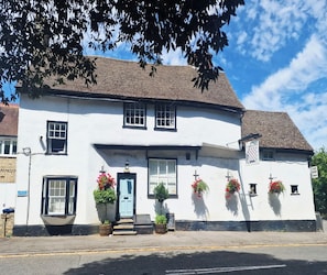 A white building with a black door, windows, and a sign that reads 'The White Lion.' - Peaceful double room with en-suite close to Cambridge (Fowlmere)