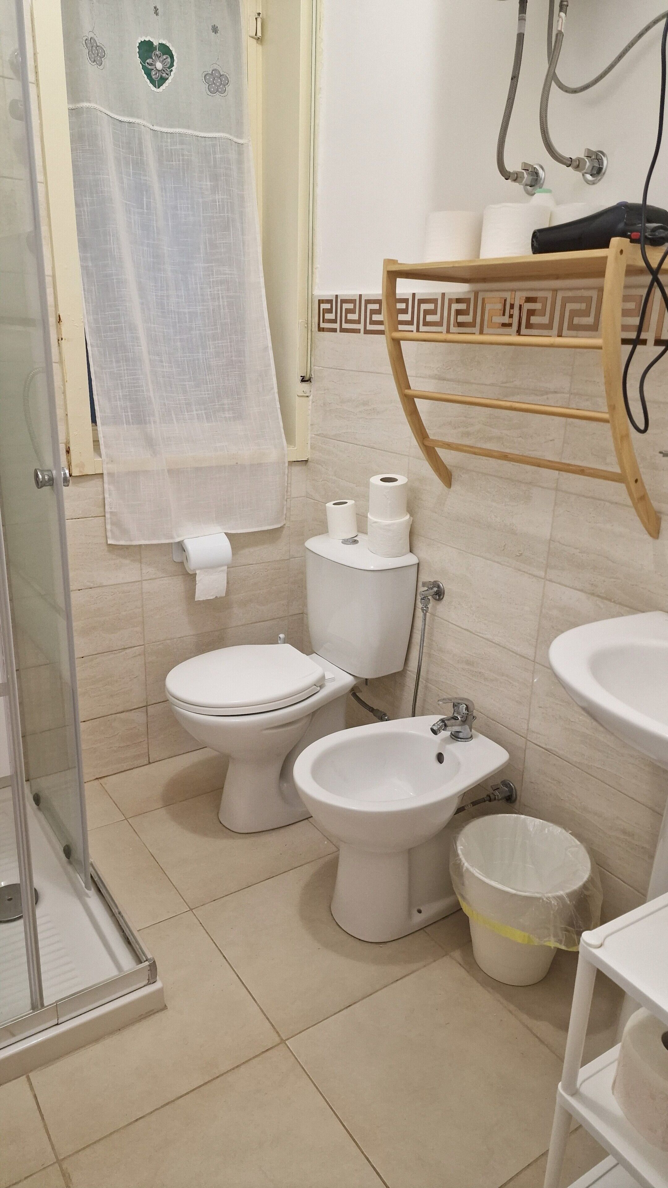 Un baño con inodoro, bidé, ducha y lavamanos.