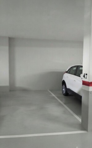 Een parkeergarage met een witte auto op een geplaatste plek.
