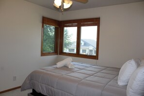 Quarto com cama, janela e ventilador de teto.