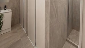 A modern bathroom with a shower enclosure, a sink, and a mirror. - Brunsi hostel (Brunswick)