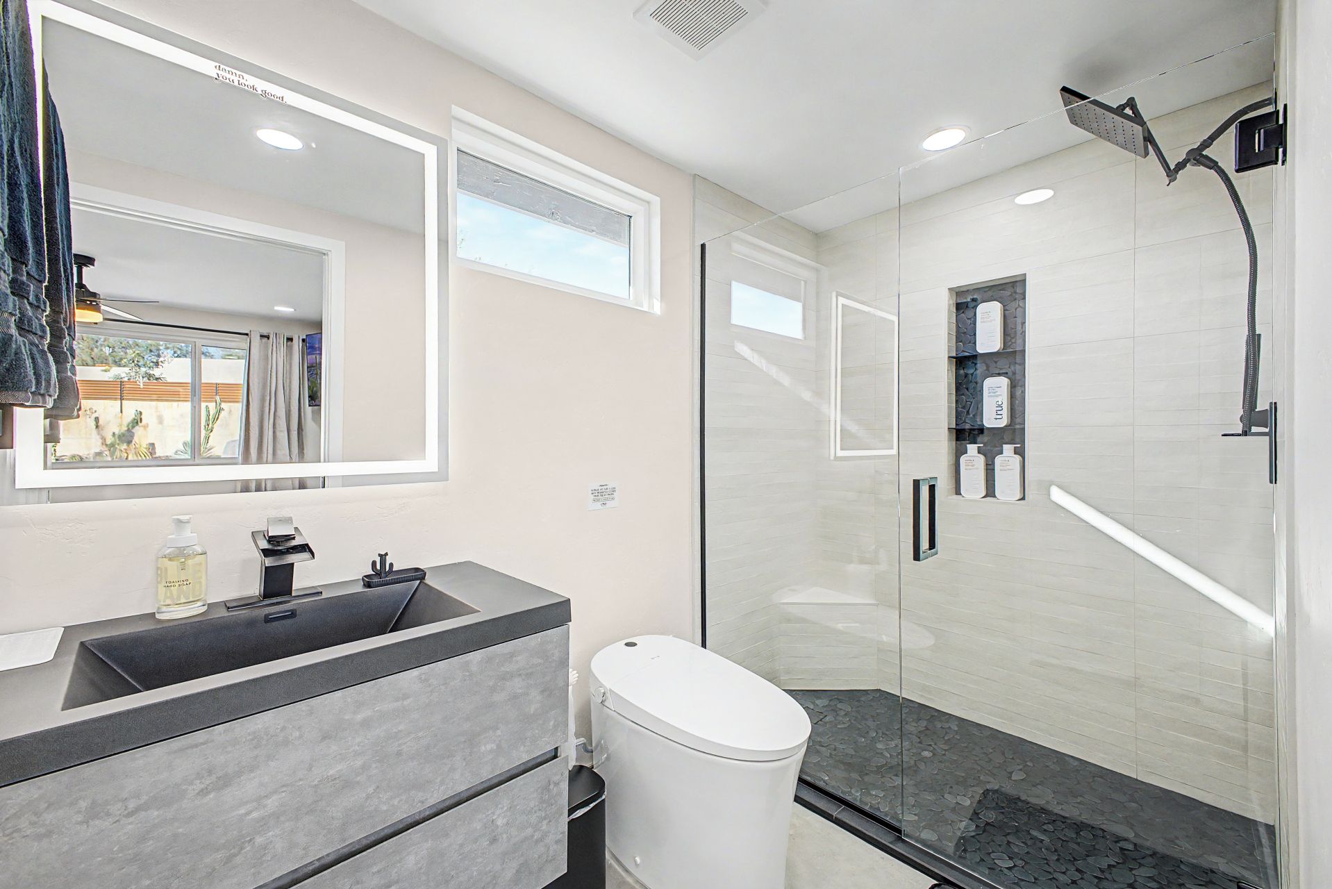 Une salle de bain moderne avec une douche à parois de verre, un meuble-lavabo et des toilettes.