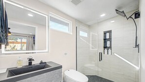 Une salle de bain moderne avec une douche à parois de verre, un meuble-lavabo et des toilettes.