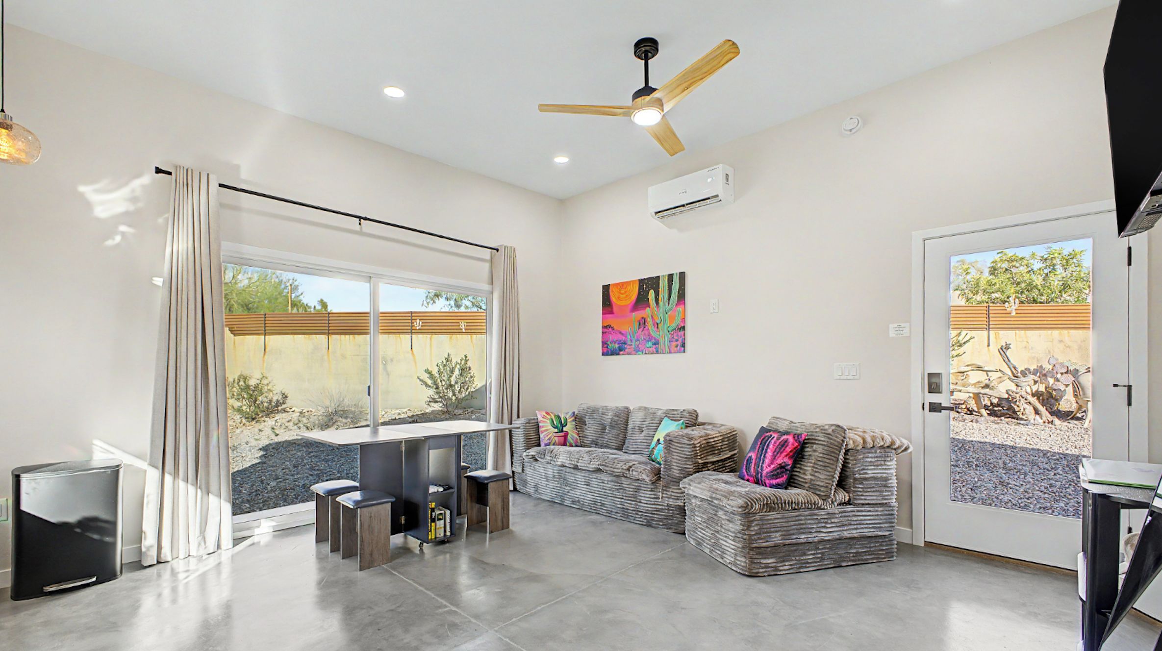 A modern living room with a sofa, a coffee table, and a ceiling fan.