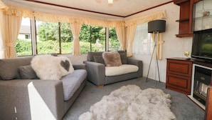 A living room with a sofa, a television, and a large furry rug.