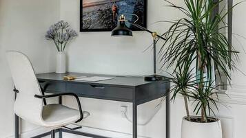 A modern office space with a desk, chair, and potted plant.