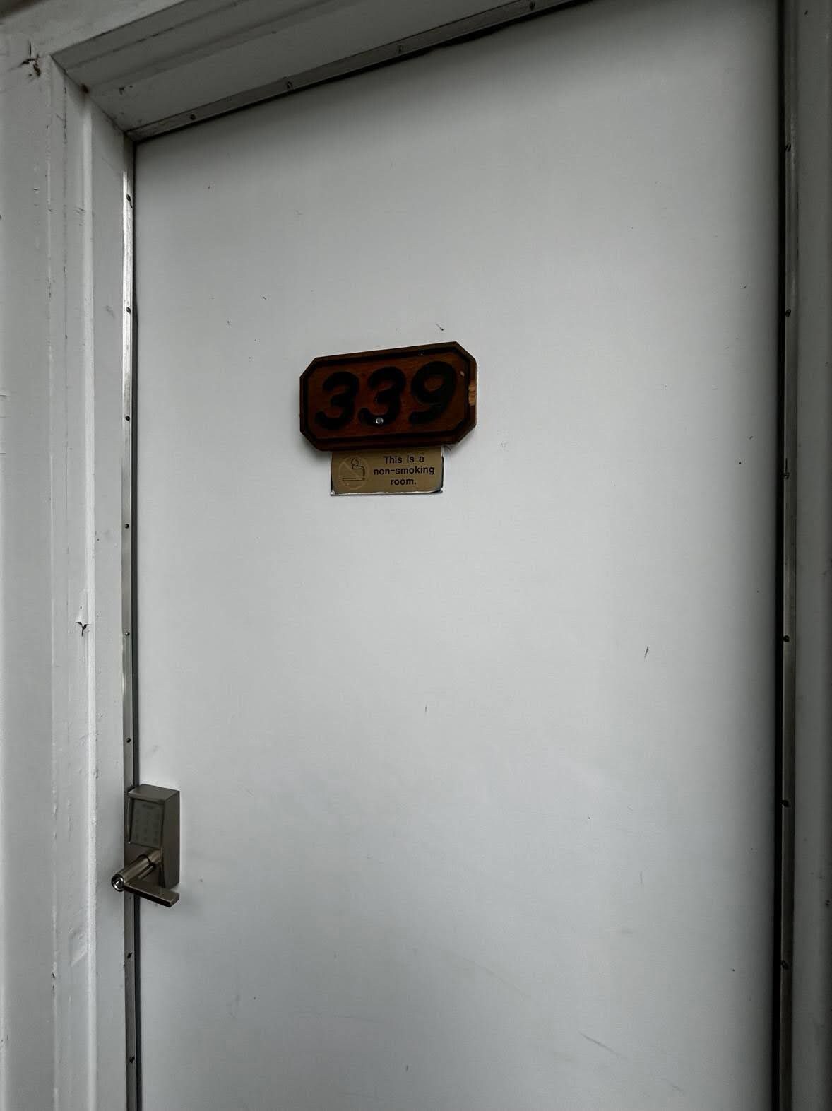 A door with a non-smoking sign and a room number sign.