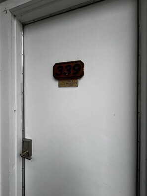 A door with a non-smoking sign and a room number sign.