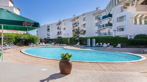 Ein Poolbereich mit Liegestühlen und einem Sumol-Sonnenschirm.