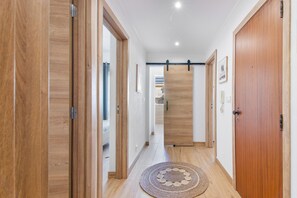 Ein Flur mit Holztüren und einem runden Teppich aus Gewebe.