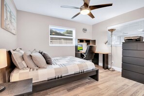 A bedroom with a bed, a desk, a chair, a wardrobe, a ceiling fan, and a window with blinds. - 2-bedroom house in adorable Largo with cool AC and charm (Largo)