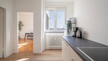 A modern kitchen with a black countertop, a coffee maker, and a radiator.
