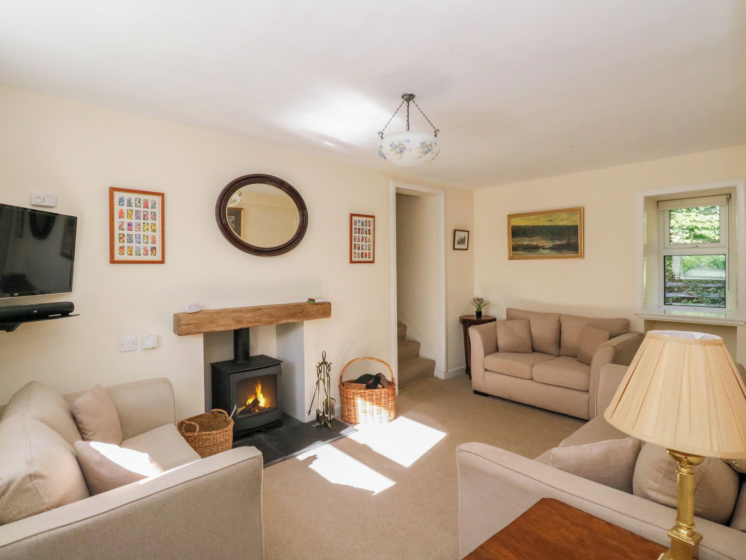 A living room with a fireplace, sofas, a television, and a lamp.