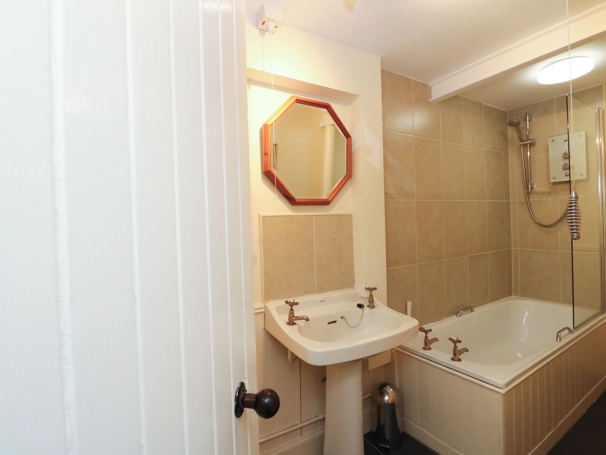 Un baño con lavamanos, espejo y bañera.