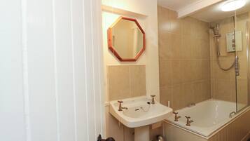Un baño con lavamanos, espejo y bañera.