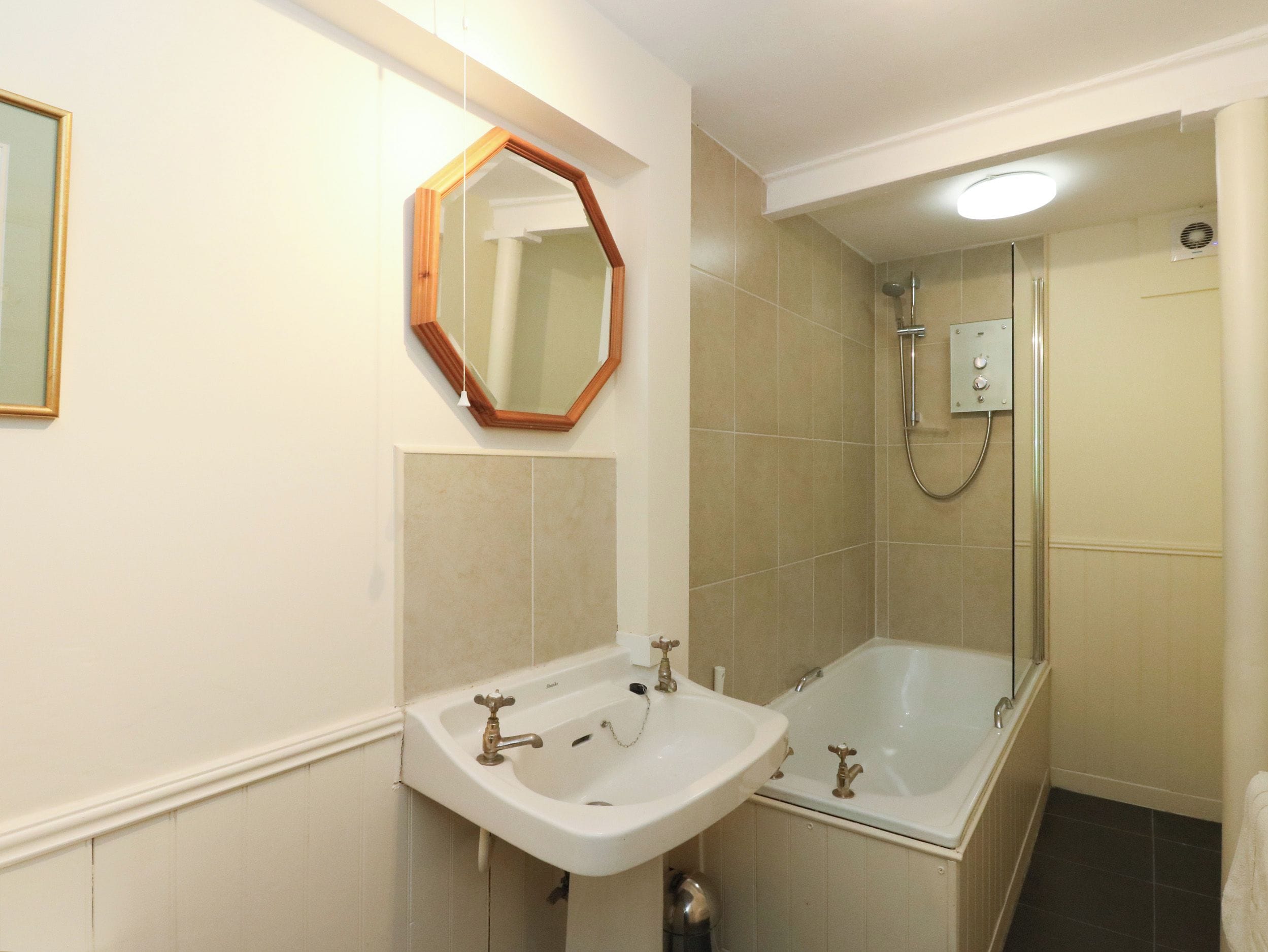 A bathroom with a sink, mirror, shower, and bathtub.