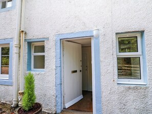 A building with a white exterior, a door, and a window.