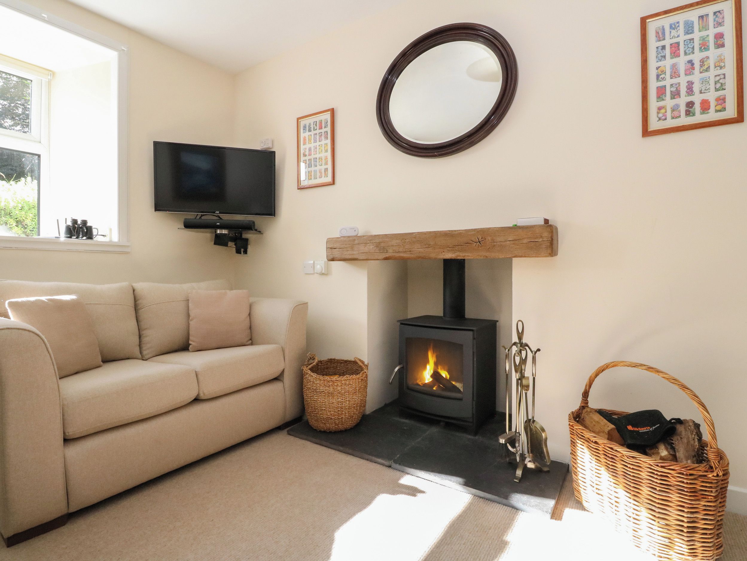 A living room with a sofa, a fireplace, a television, and a framed picture on the wall.